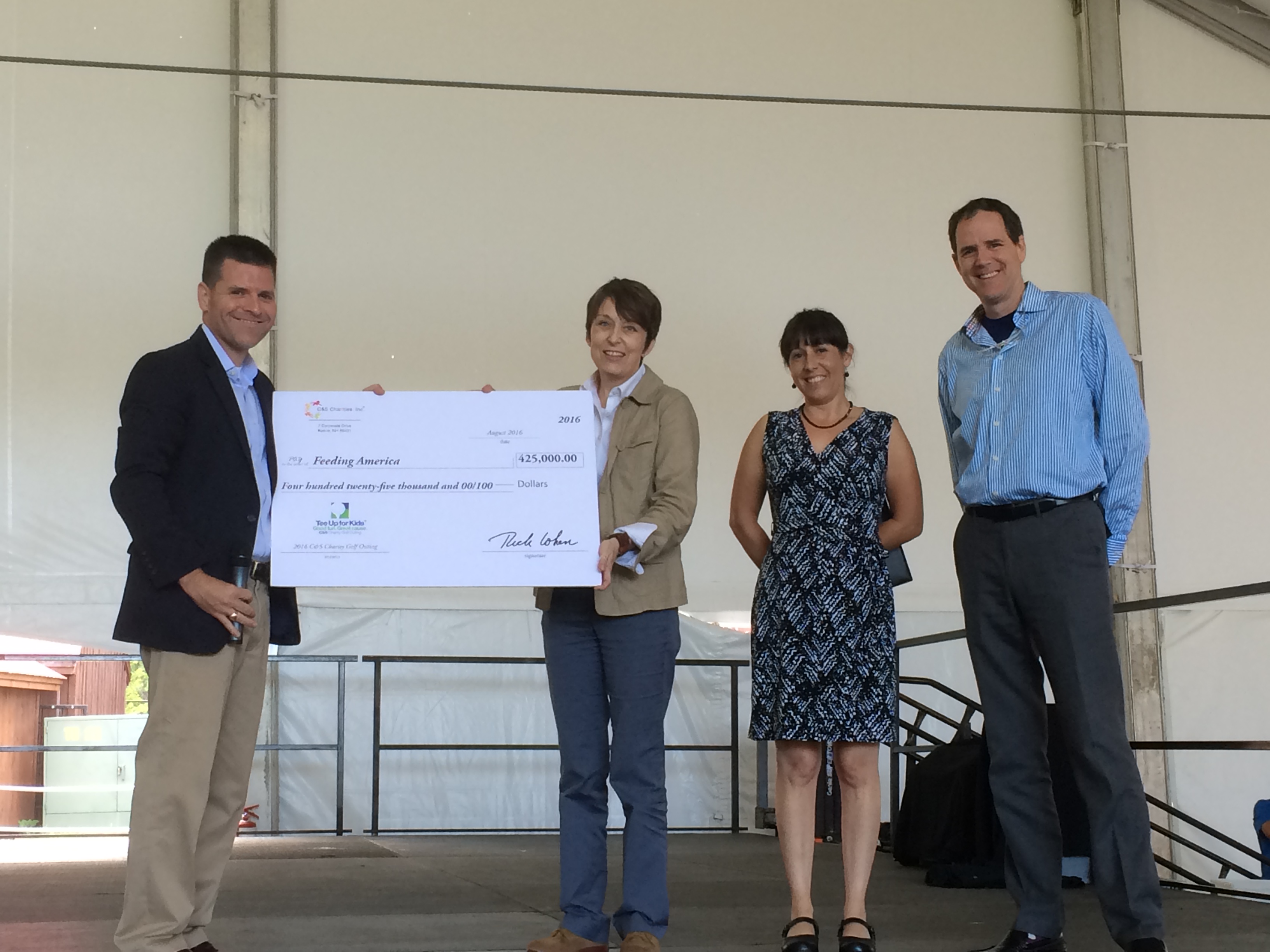 Bryan Granger, C&S Charities secretary (left), presented a ceremonial check to representatives of Feeding America, one of six nonprofit organizations honored at the Tee Up for Kids™ Golf Outing.