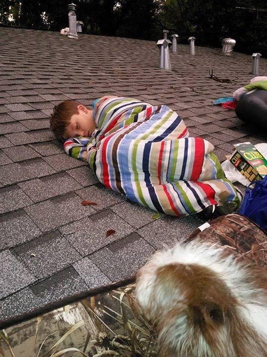 Young child waiting to be rescued from the roof.