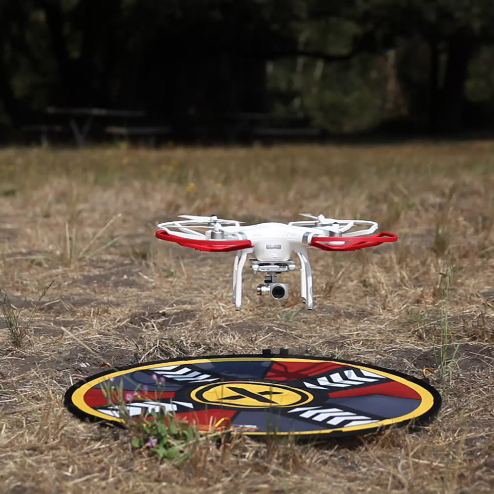 Drone hovering over 32" FlatHat Collapsible Drone Pad
