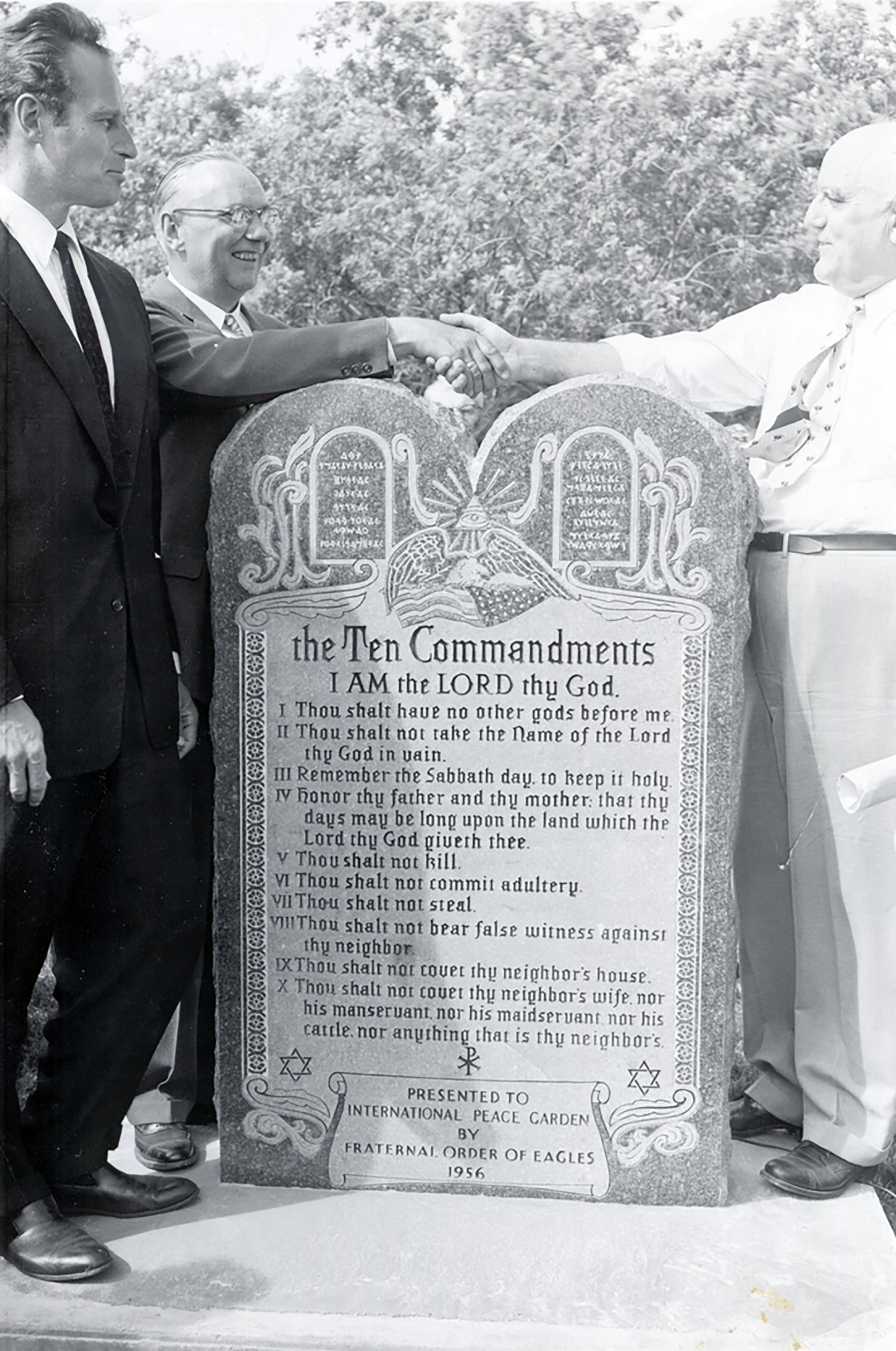 Actor Charleton Heston (left) and director Cecil B. DeMille (right) stand beside Ten Commandment installation with F.O.E. representative in 1956.