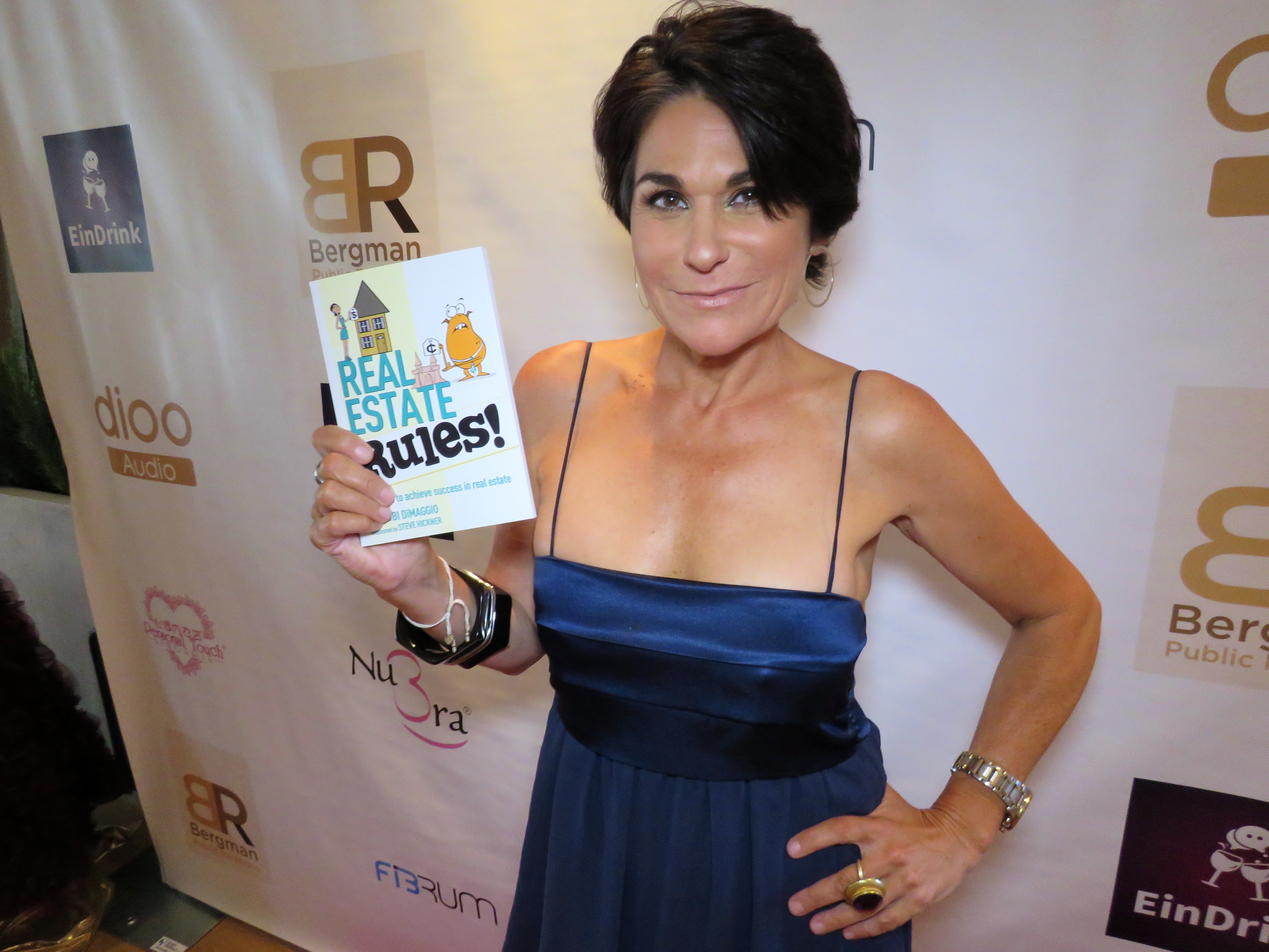 Author Debbi DiMaggio with her latest book, Real Estate Rules!