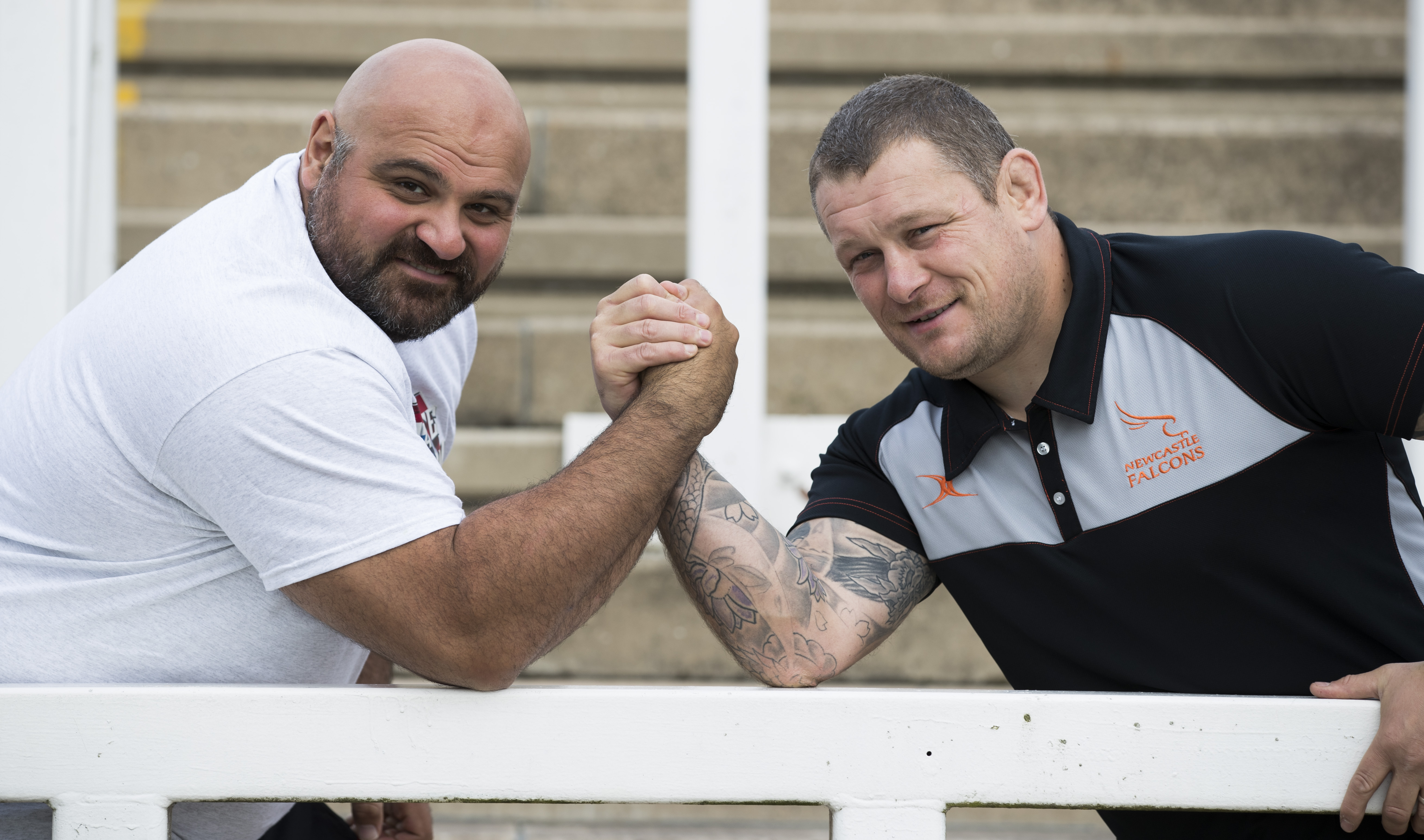 Laurence Shahlaei takes on Newcastle Falcons coach Micky Ward at an arm wrestle
