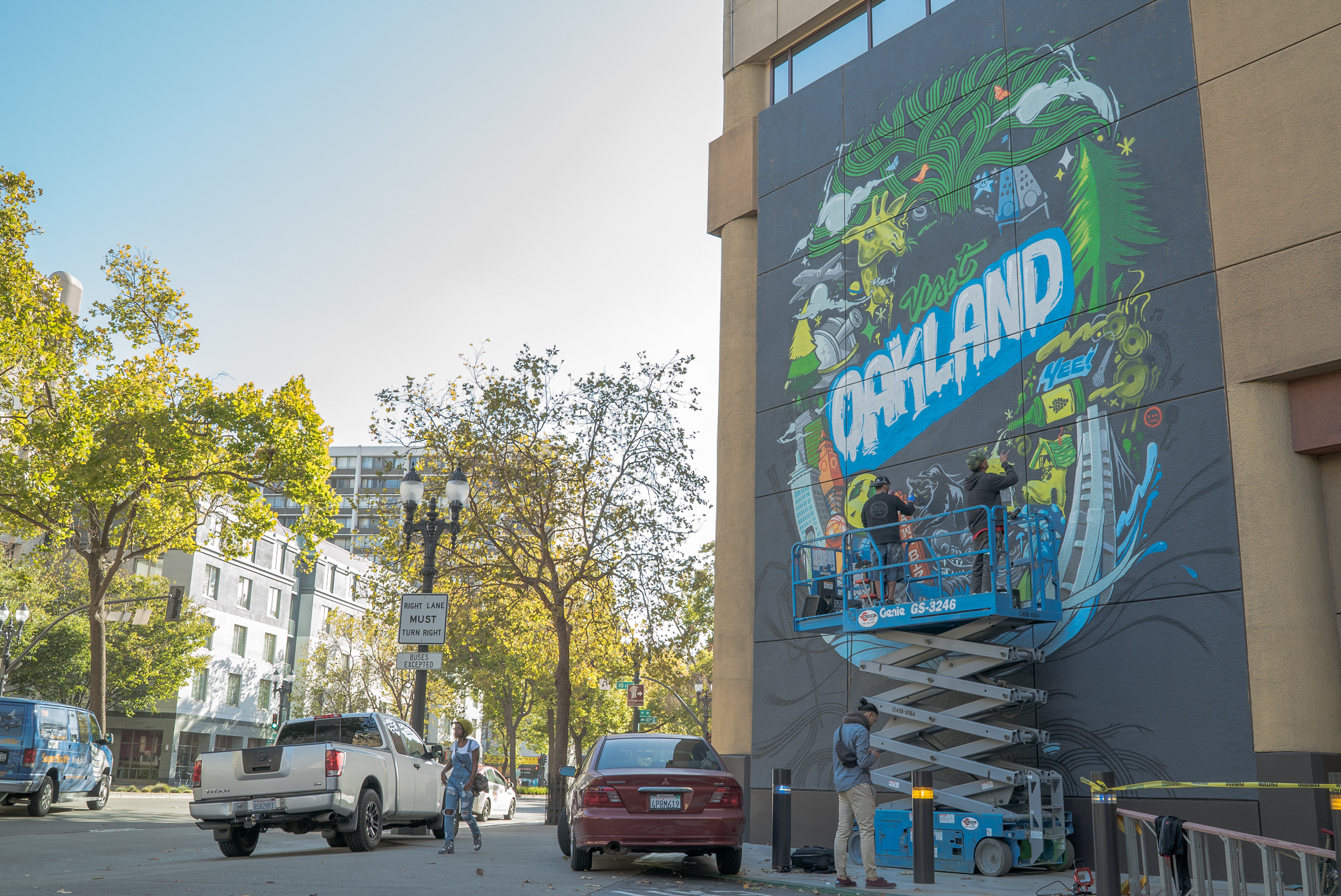 The Illuminaries work on the Visit Oakland Mural in Downtown Oakland
