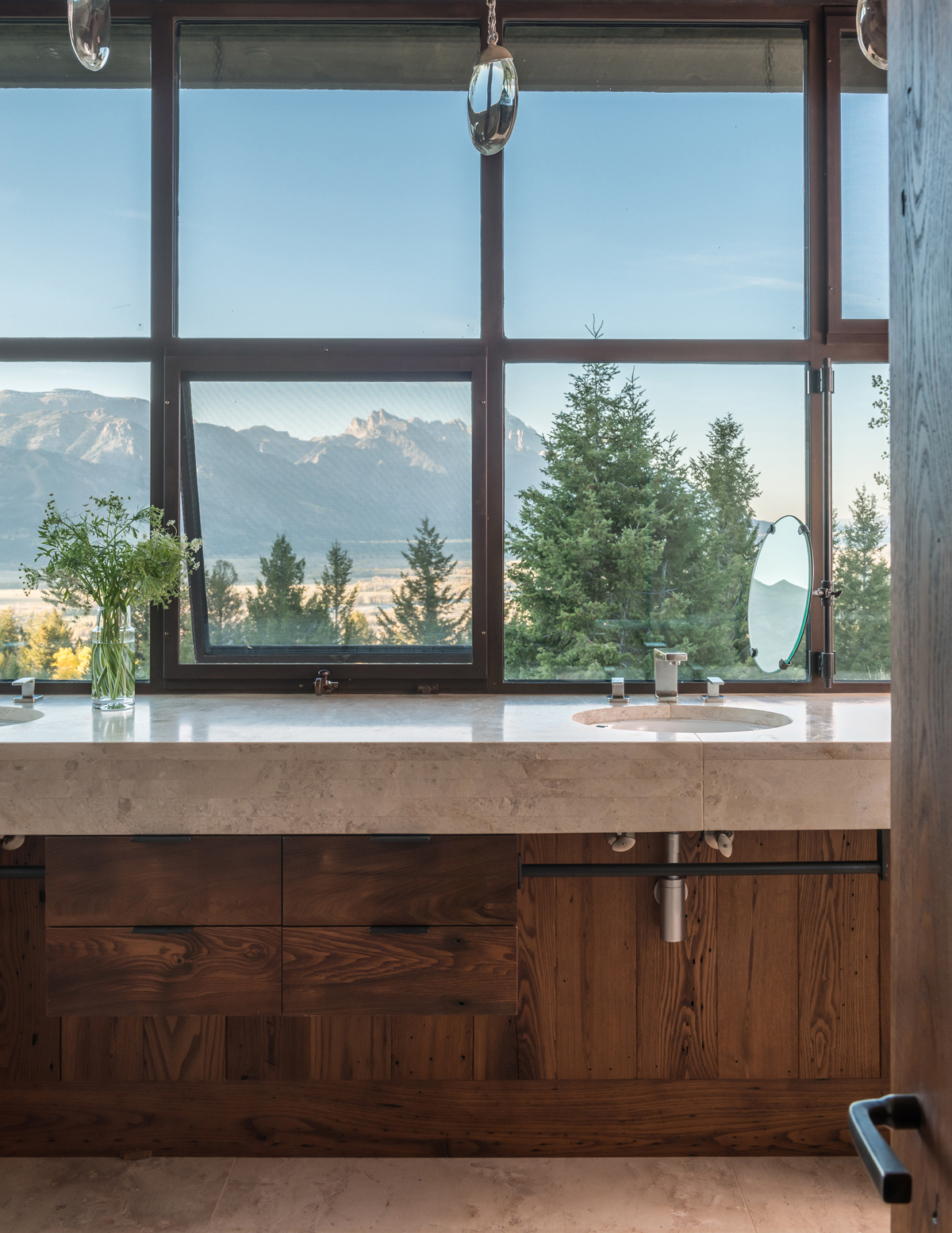 A small custom-made oval stands in for the expected large master bath mirror so homeowners can enjoy dramatic Teton views (photo by Audrey Hall).