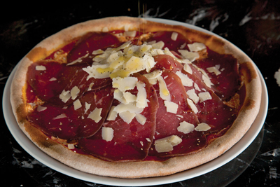 Thea's hand-made pizzas feature gourmet ingredients like prosciutto and truffle oil.