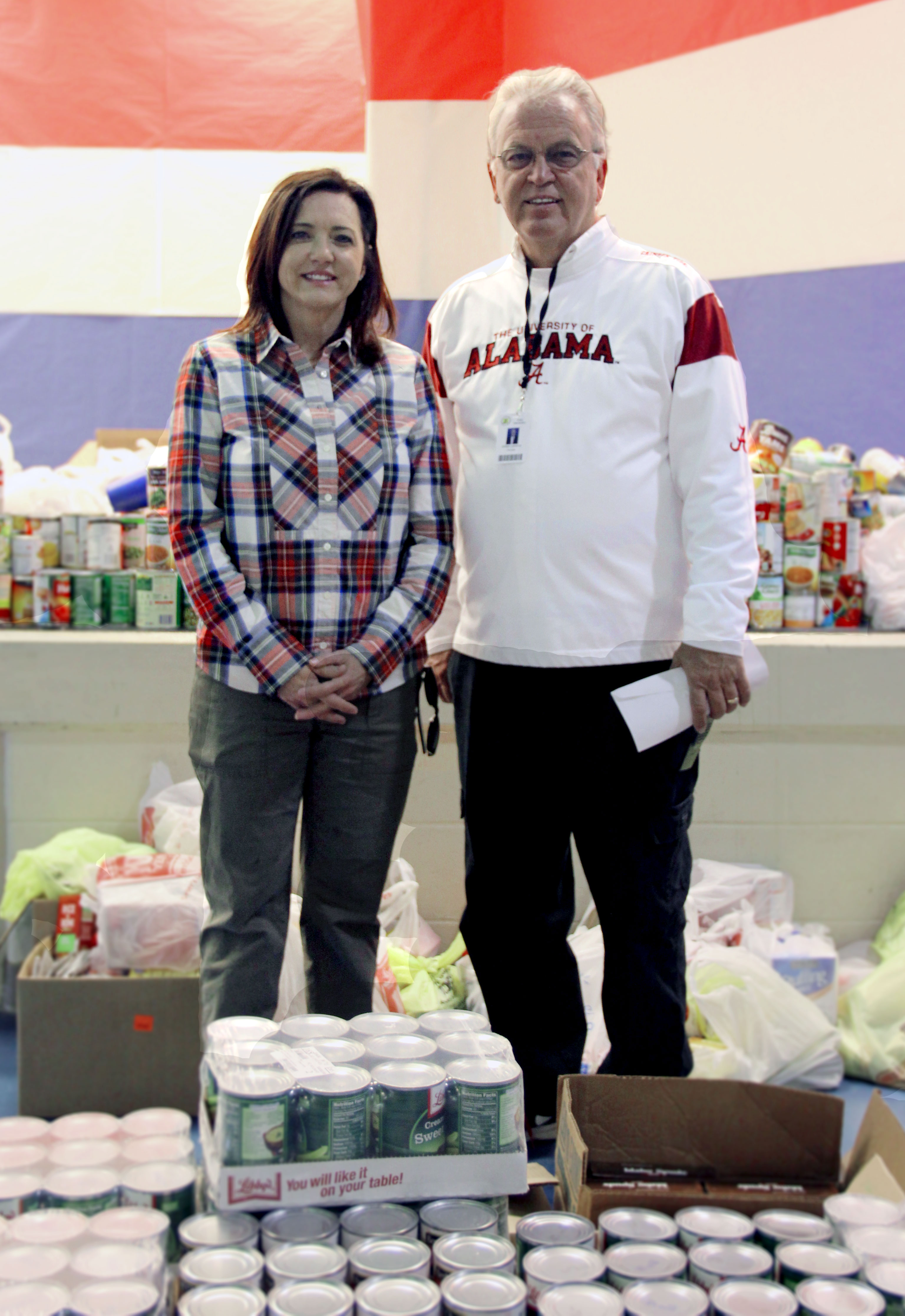 Columbia Southern University Senior Vice President Chantell Cooley and Foley Elementary Principal William Lawrence pose with food donations to Turkey Take-Out.