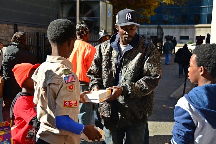 Picture from 2014 Event Young Scout Handing Food to Man