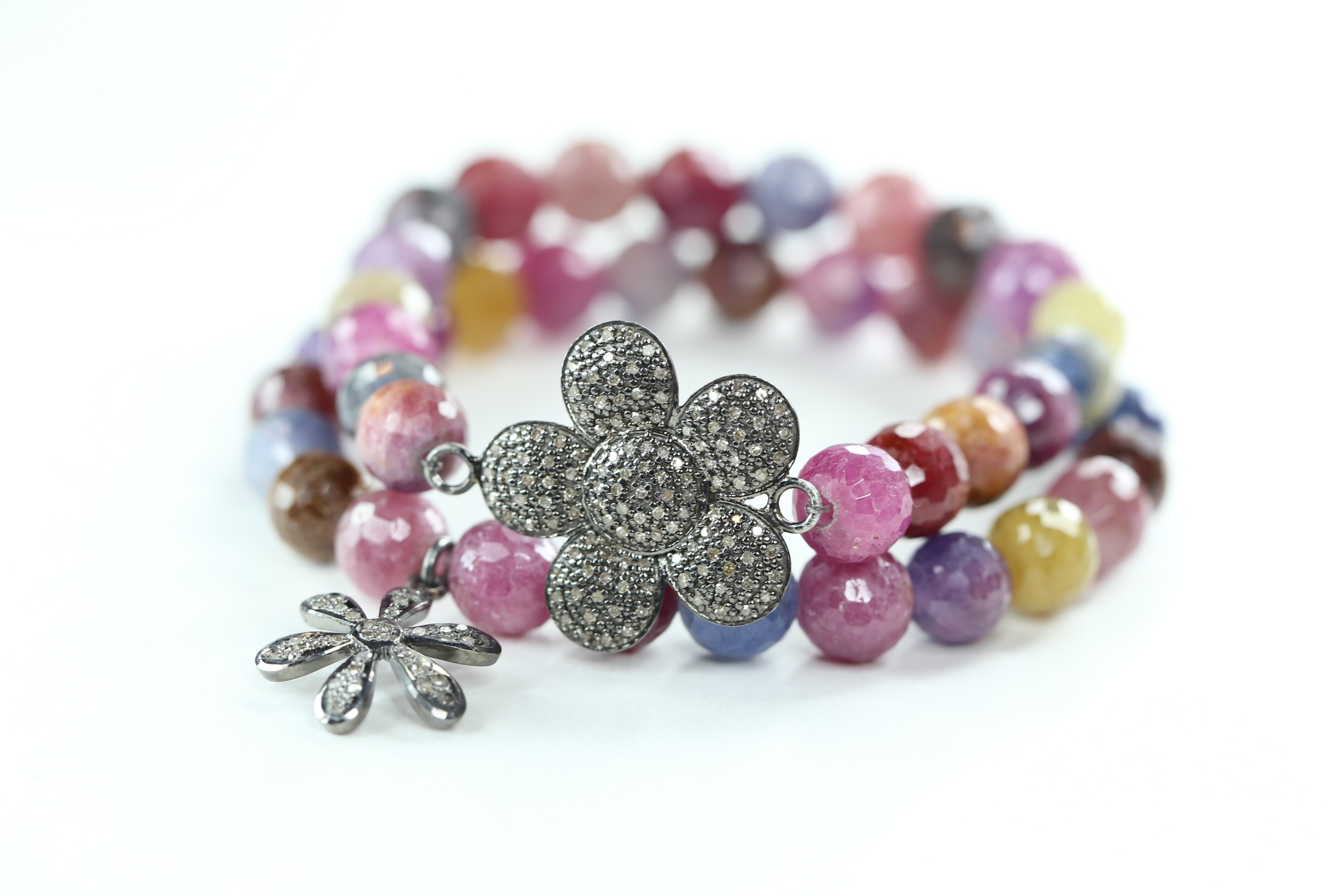 Bracelet sets with muted large sapphires and pave diamond flowers.