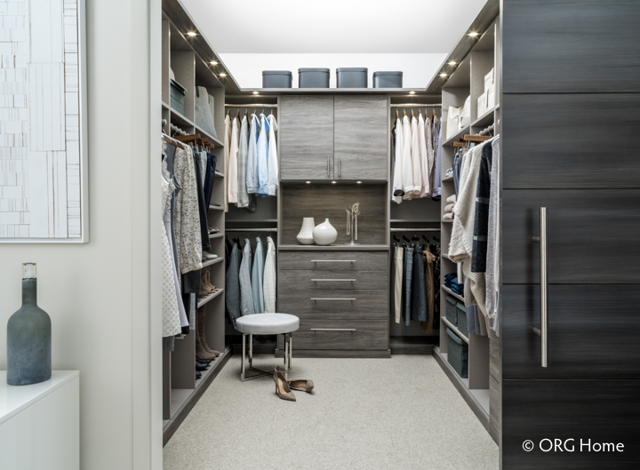 An ORG Home custom closet with clean lines, stylish hardware and an elegant two-tone color scheme keeps your space feeling calm and serene.