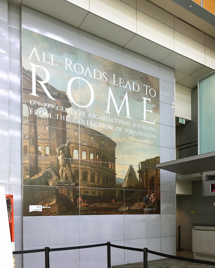 Signage being installed for All Roads Lead to Rome Exhibit at SFO International Terminal