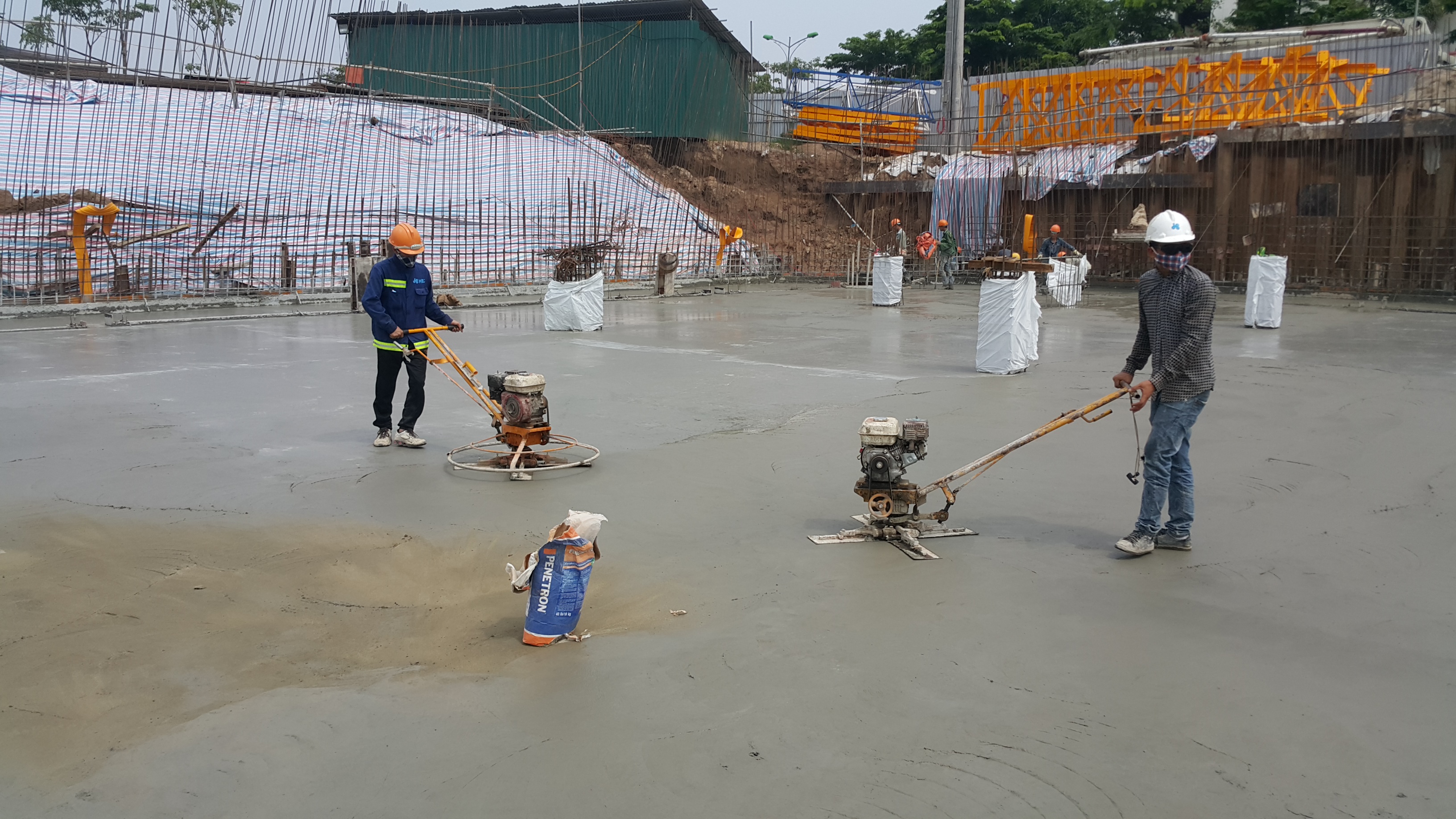 PENETRON goes to work: After an initial dry shake application, PENETRON PLUS will give greater impact and abrasion resistance to the concrete substrate at An Binh City, Hanoi.