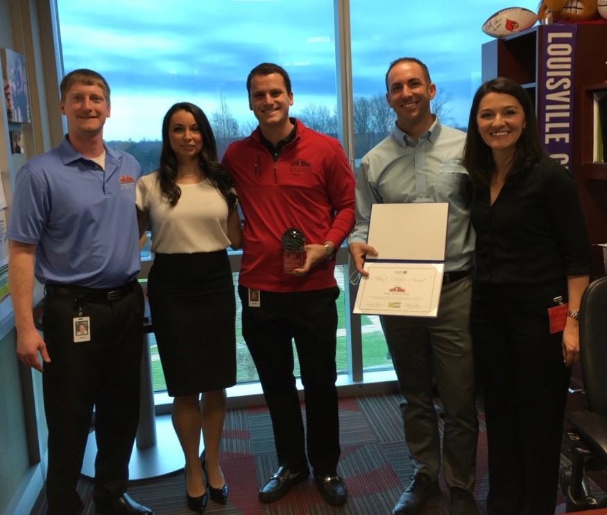 Alicia Myers and Maria Chacon of BARE International present the first annual Client Choice Award to Royce Lurie, Jordan Marr, and Jason Wade from Papa John’s Pizza, pictured left to right.