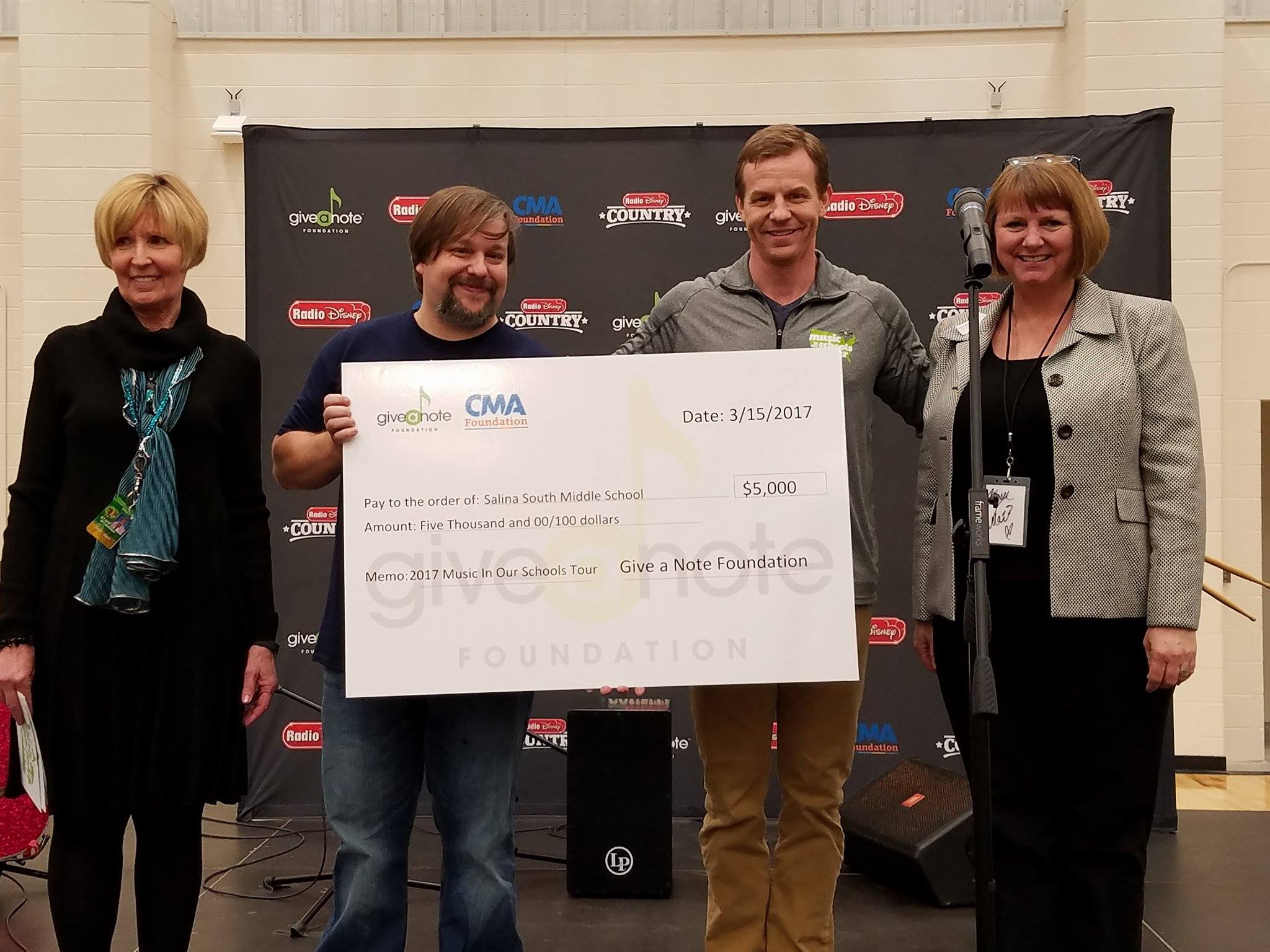 Salina South Middle School teacher Matt Gerry receives a grant check from Give a Note Foundation.