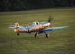 The museum's Messerschmit Bf-109 takes off as the sun sets on the grass runway.