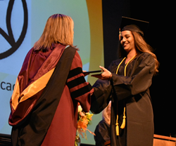 Graduate receives diploma during commencement