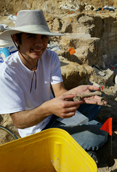 Photo of Trey Hall holding a fossil at a dig in Florida
