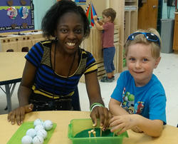 Photo of Kelsey working on a project with a preschool student.