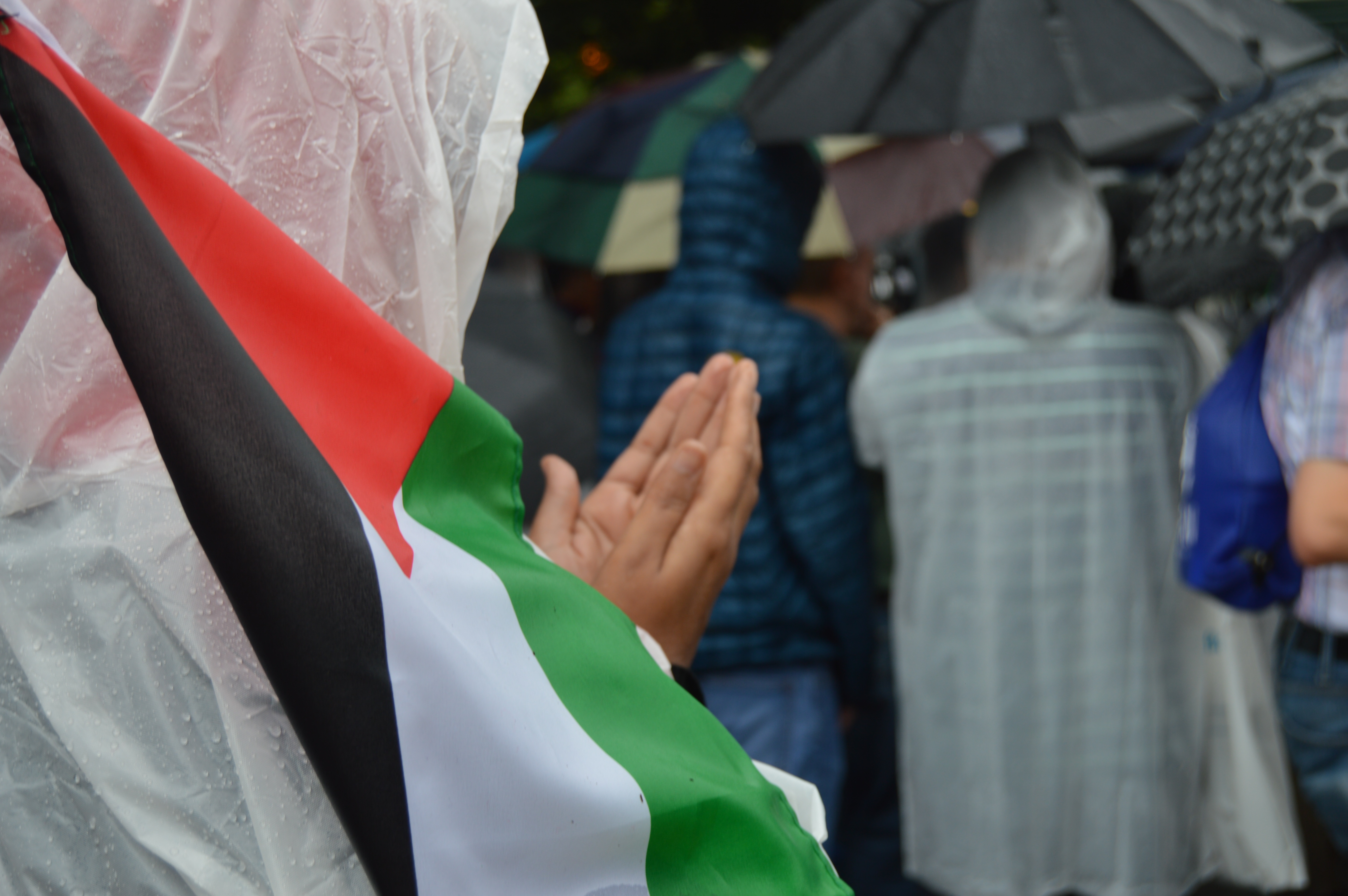 A young woman prays while holding a Palestinian flag during a prayer service outside the Israeli embassy in Washington D.C. on Friday, July 28, 2017.