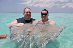 Cruise Planners franchise owner Lori Osgood, right, of Jacksonville, Fla. is pictured with her husband Richard Osgood at Stingray City in Grand Cayman, Cayman Islands.