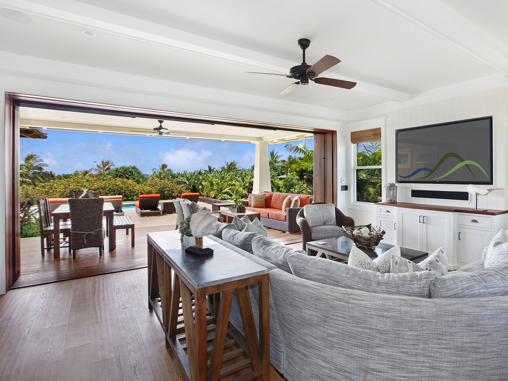 Glass walls open in the living room to lanai.