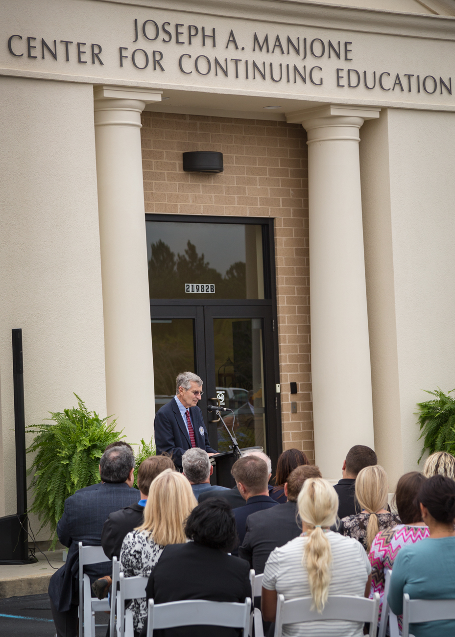Joseph A. Manjone speaks at ceremony in front of the building now bearing his name on Monday in Orange Beach, Alabama.