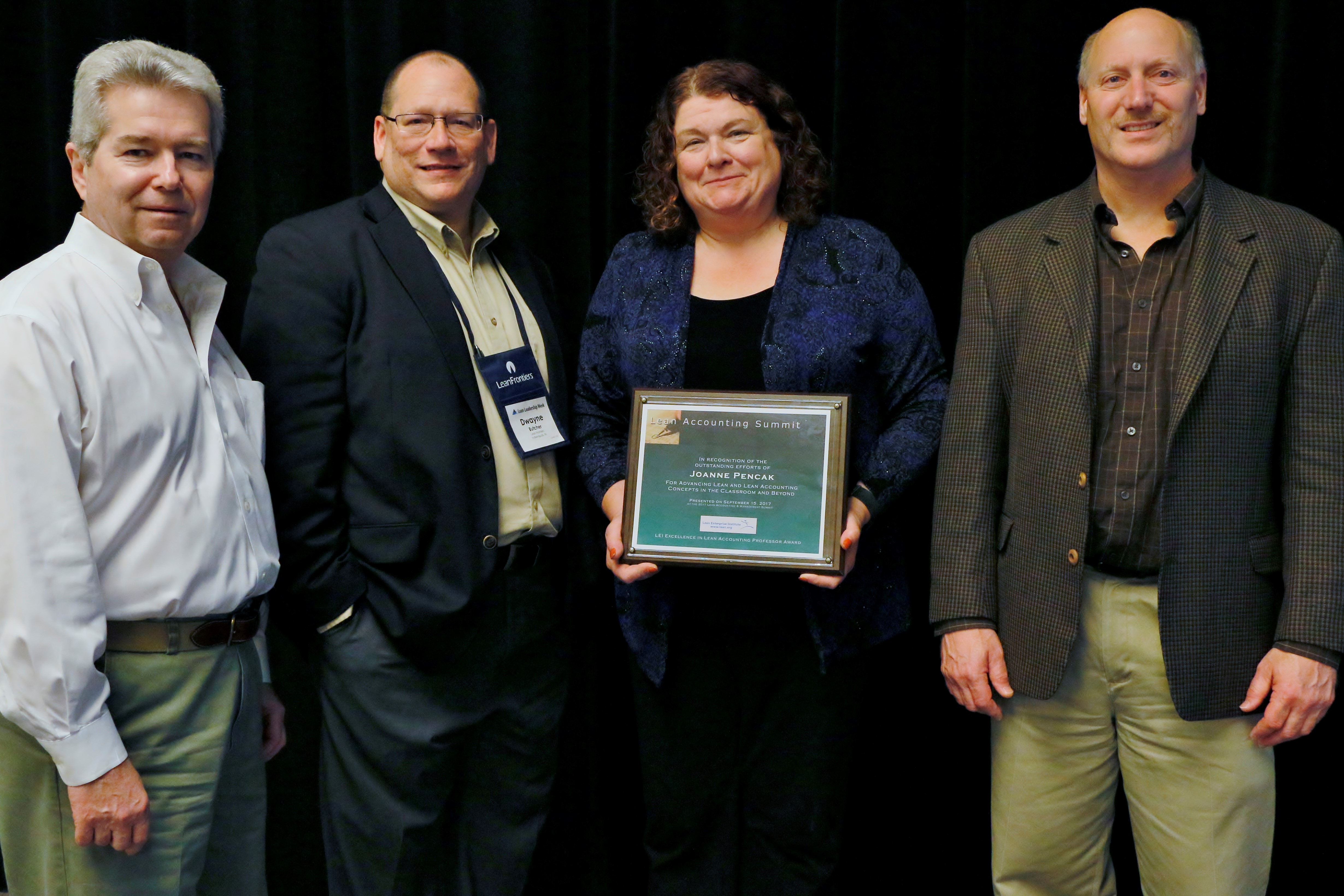 Joanne Pencak accepts the 2017 Excellence in Lean Accounting Award from, left to right: Chet Marchwinski, LEI communications director, Dwayne Butcher, Lean Frontiers vice president, and Jim Huntzinger