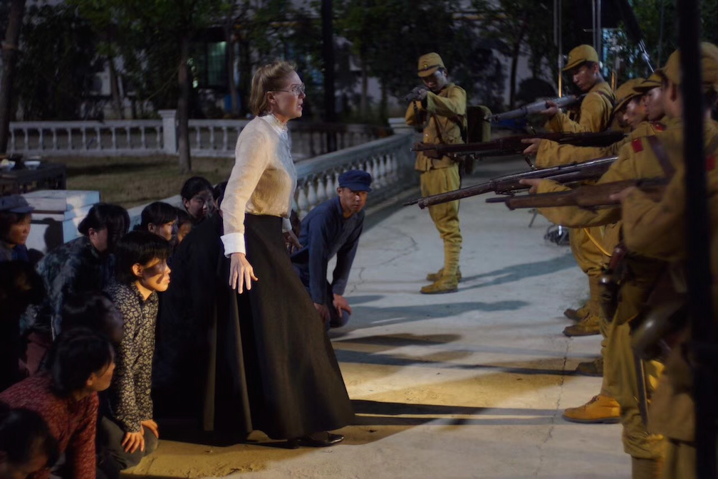 Minnie Vautrin (Ines Laimins) faces off with Japanese soldiers in SCARS OF NANKING