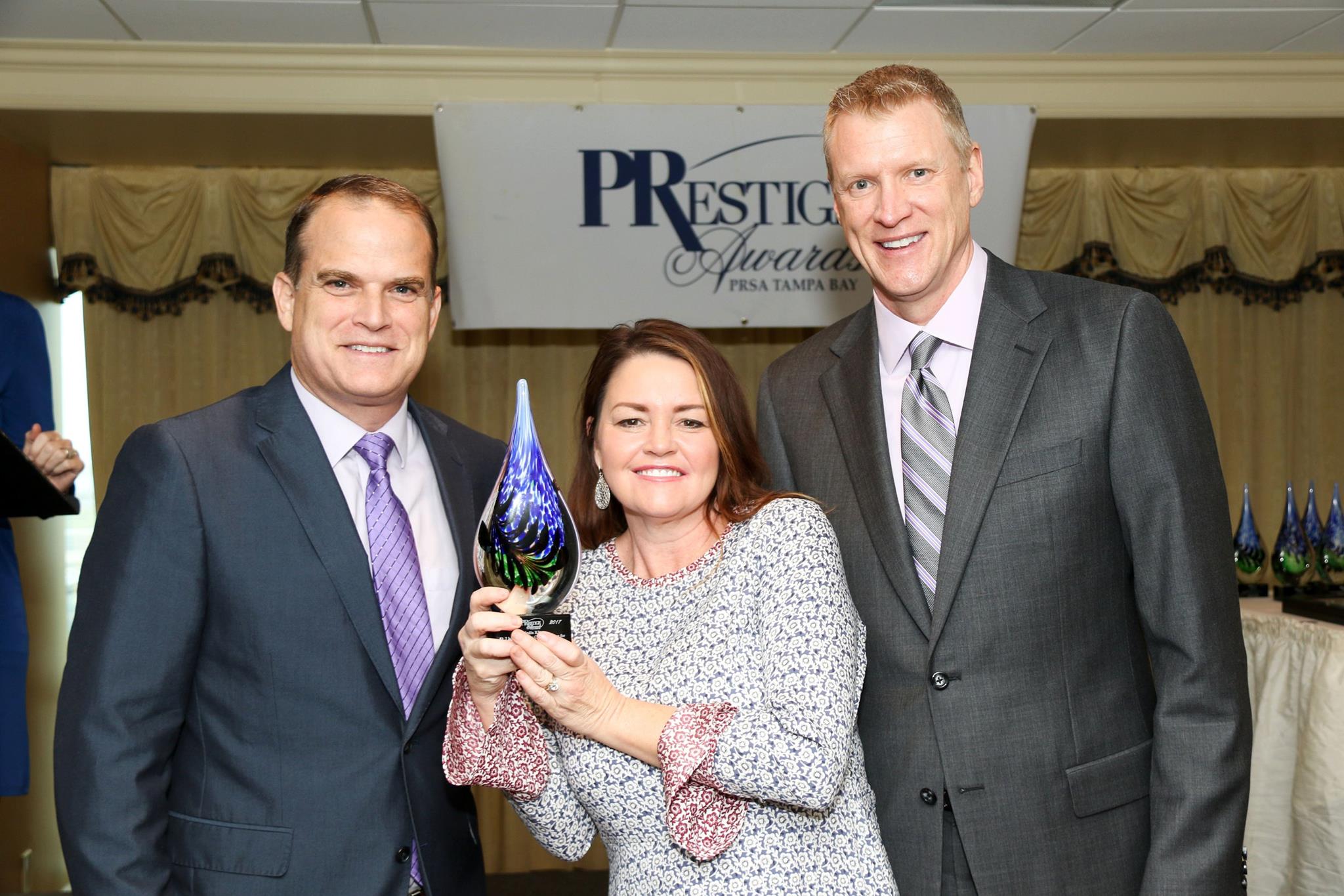 PRmediaNow's Colin Trethewey (left) & Coleen Murphy (center) receive a 2017 PRSA Tampa Bay PRestige Award