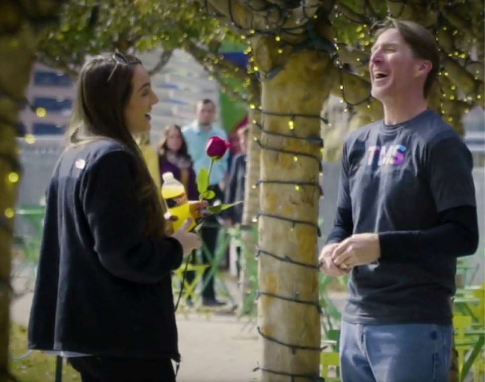 TMS employee passes out roses to locals in a Dallas park, spreading smiles and happiness as they accept his gift.