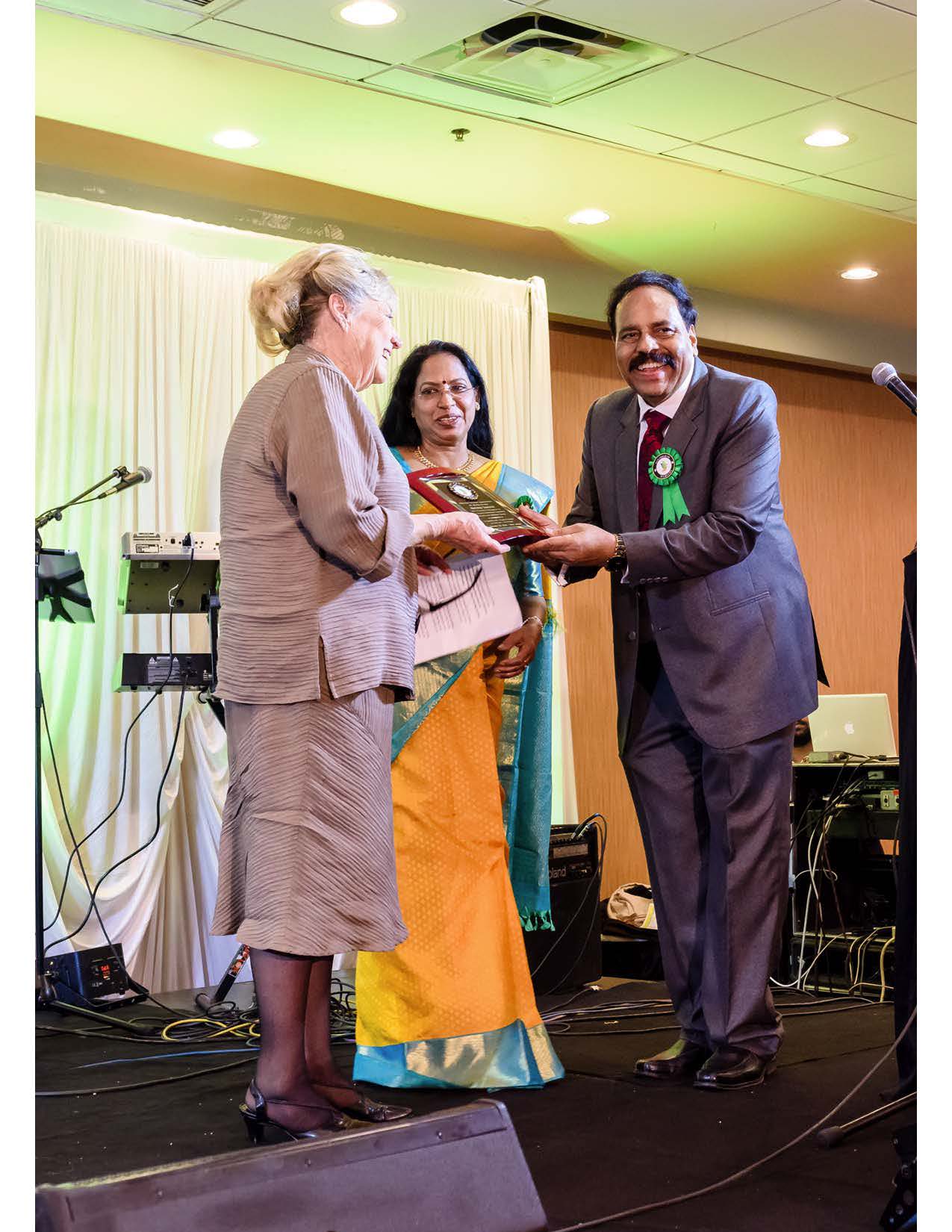 Santhigram Founders honoring Ms. Melinna Giannini, President of Insurance Consulting company, with an award for her excellent services provided to Santhigram