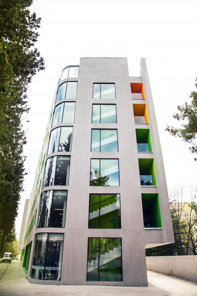 Bold colors and a curved façade mark the six-floor maternity hospital in the Georgian capital city of Tbilisi, featuring three distinct styles on each of its sides.