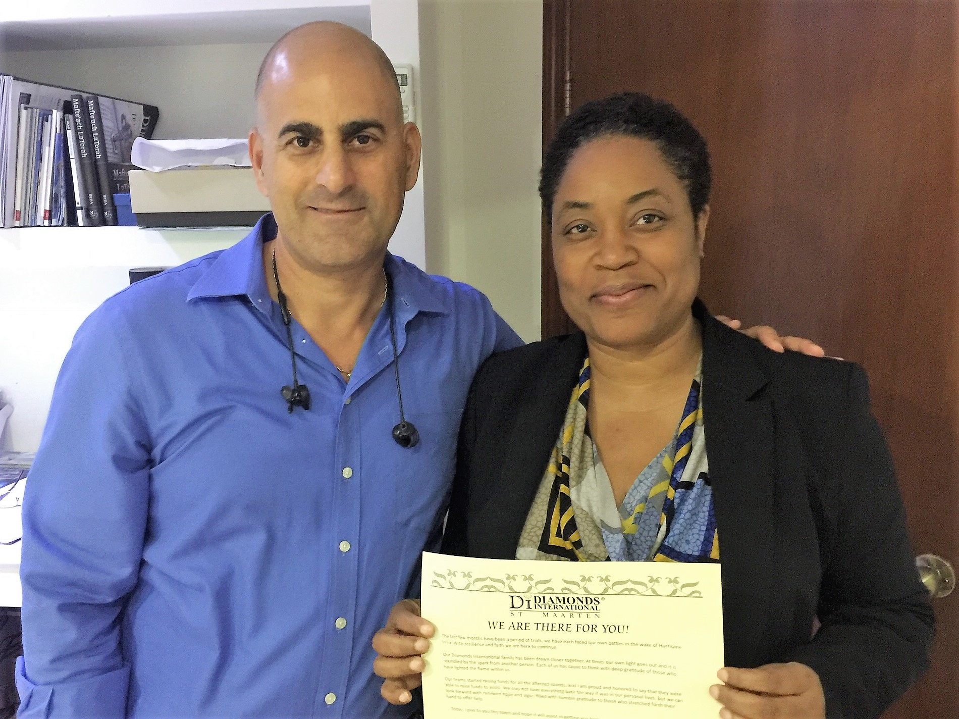 Employee in St. Maarten being given Diamonds International's relief funding by a Regional Director