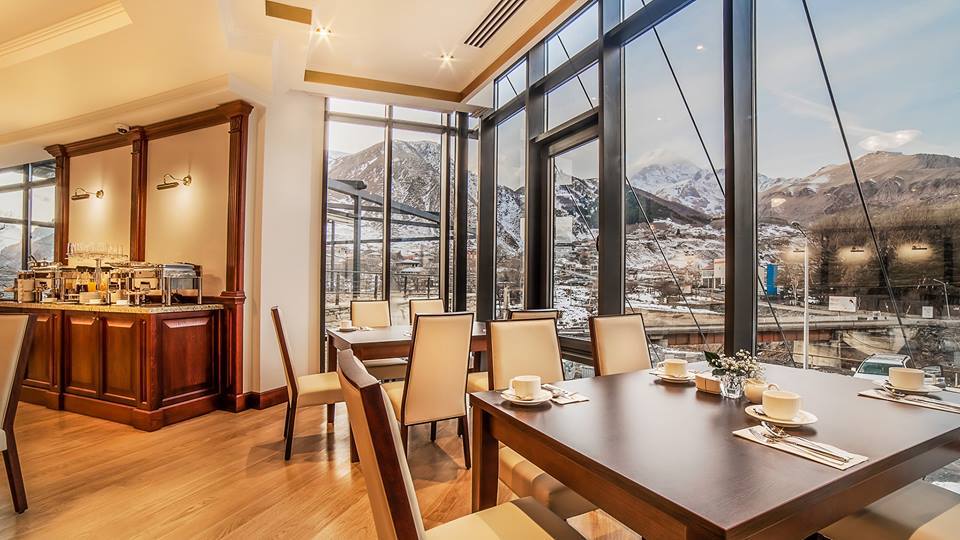 Warm interior, snow-covered exterior: The dining room of the Porta Caucasia hotel offers panoramic views of the Kazbegi Mountains, a popular skiing and hiking destination.