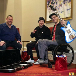 Eric Howk Receives a Goldfinch Guitar as a Thank You Gift from NTI during the interview with Mike Sanders, Director of NTI and bassist Zach Carothers.