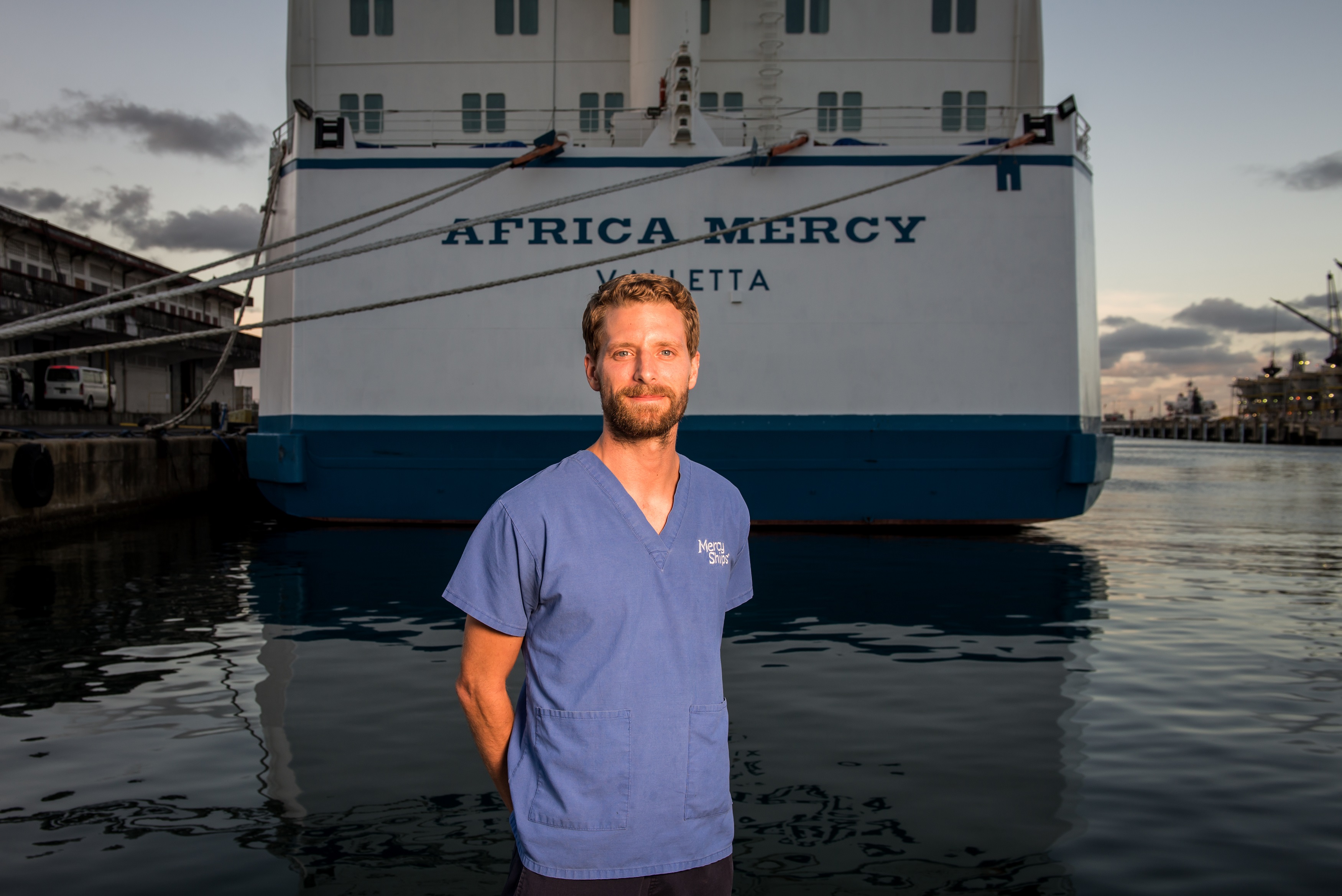 Nathan Claus stands on the dock near the world's largest private hospital ship, the Africa Mercy. ©Mercy Ships, credit: Ruben Plomp