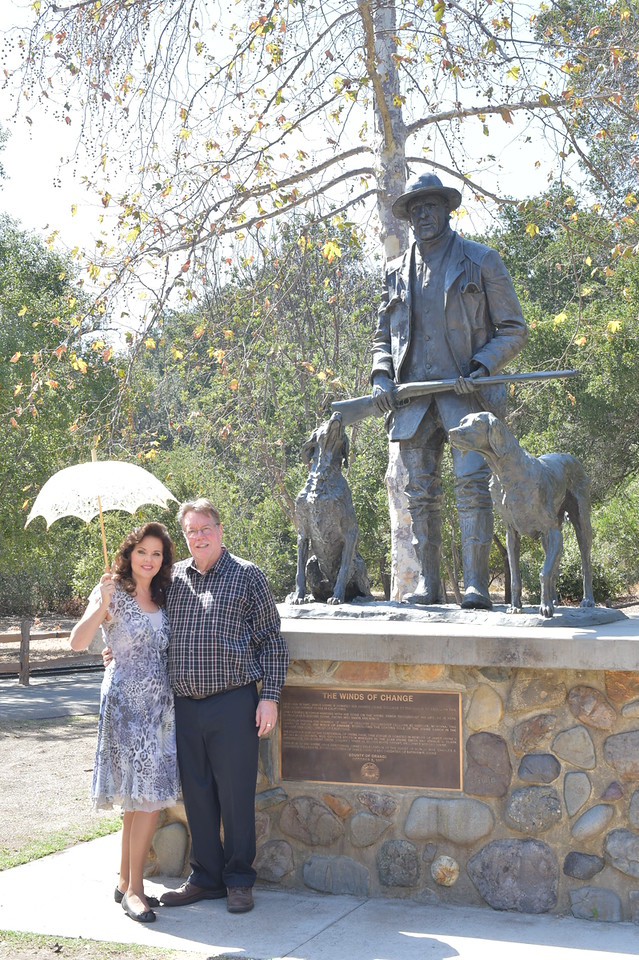Susan and Jim stand in front of James grandfathers statue James Irvine II located in Irvine Regional Park.