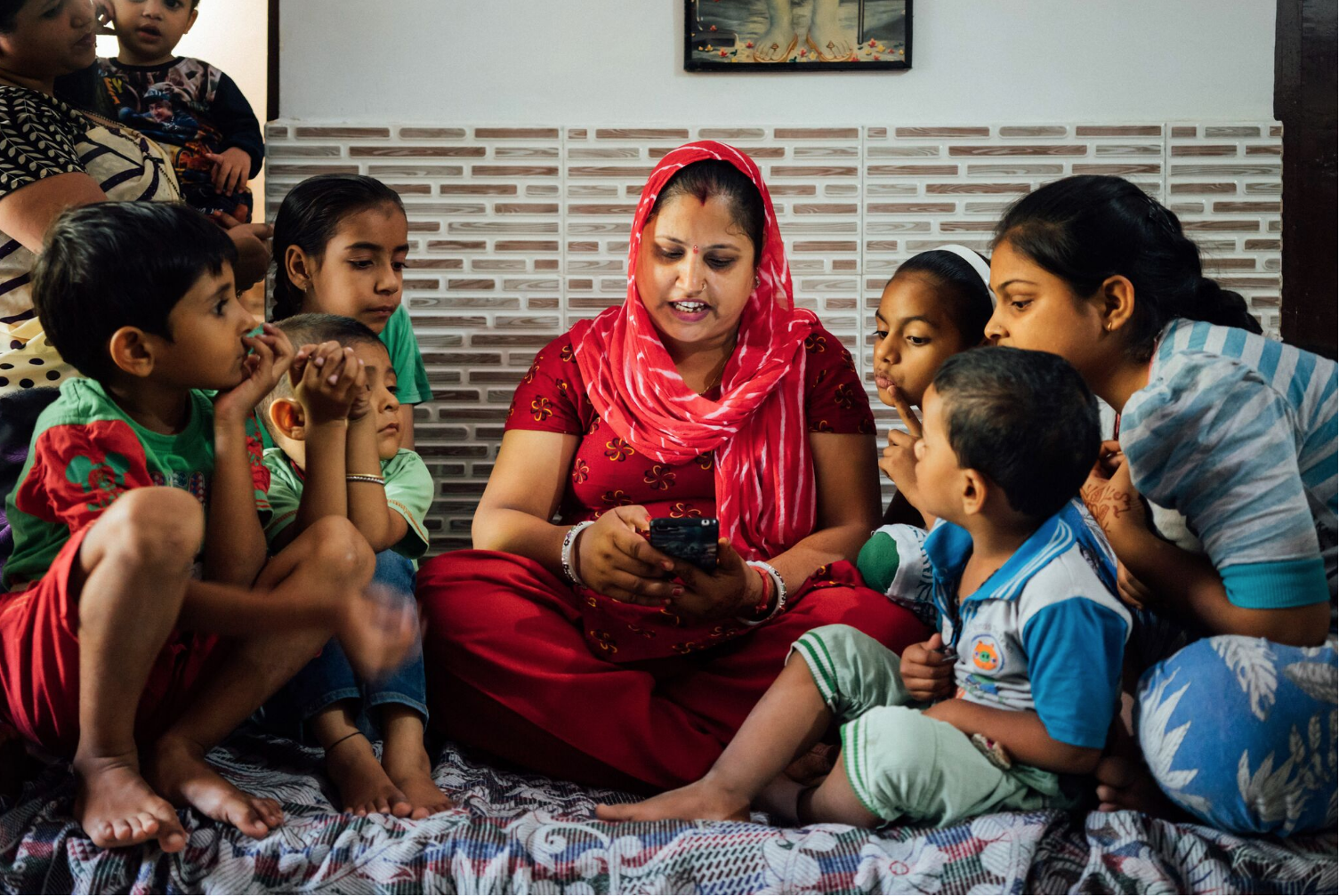 A mother in South Delhi reading to her kids and nephews using Worldreader's free Read to Kids application.