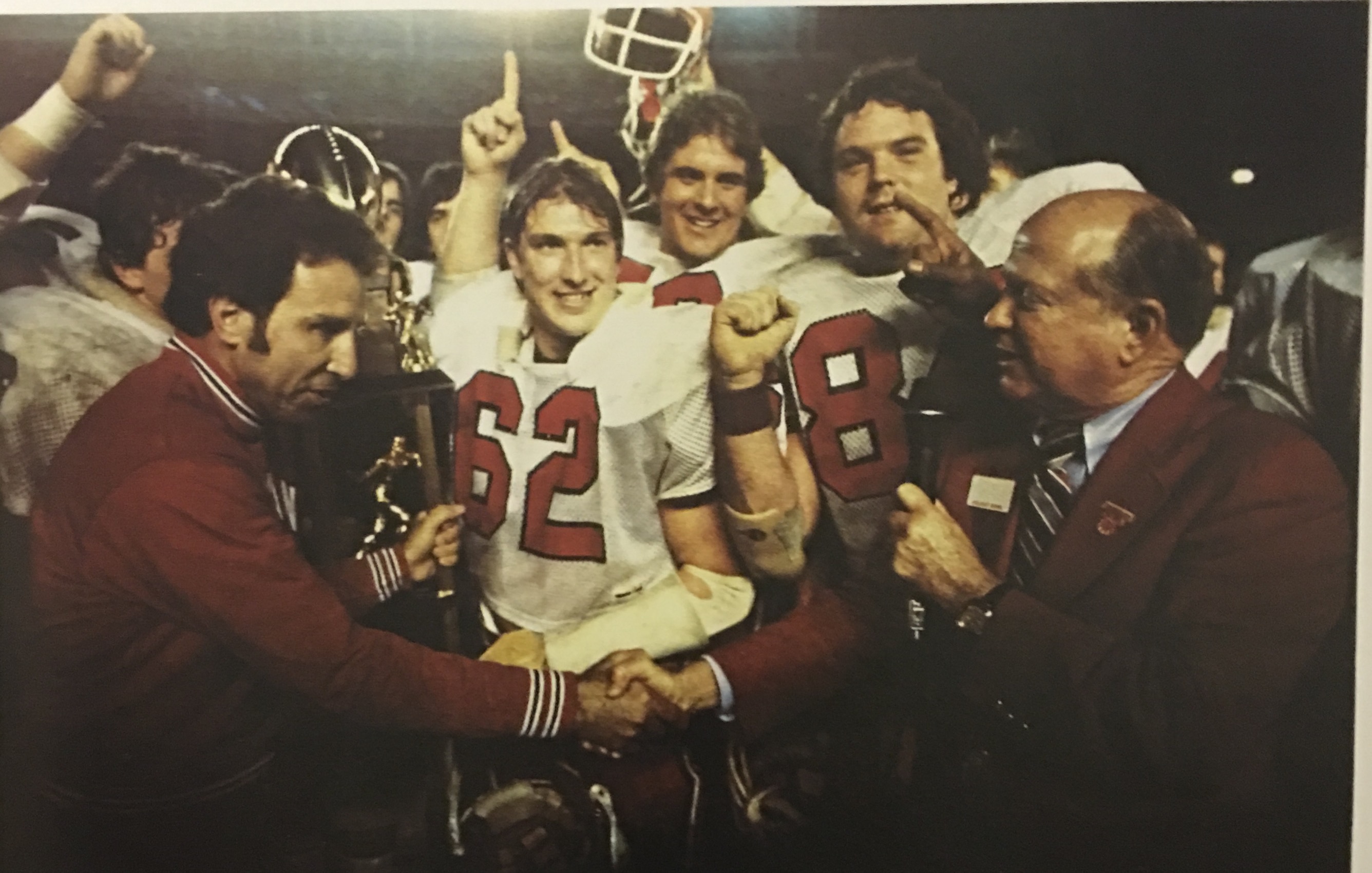 Indiana University Football Coach Lee Corso, Terry Tallen #62; Kevin Speer #59 and Bob Stephenson #84 being awarded the 1979 Holiday Bowl Championship Trophy.