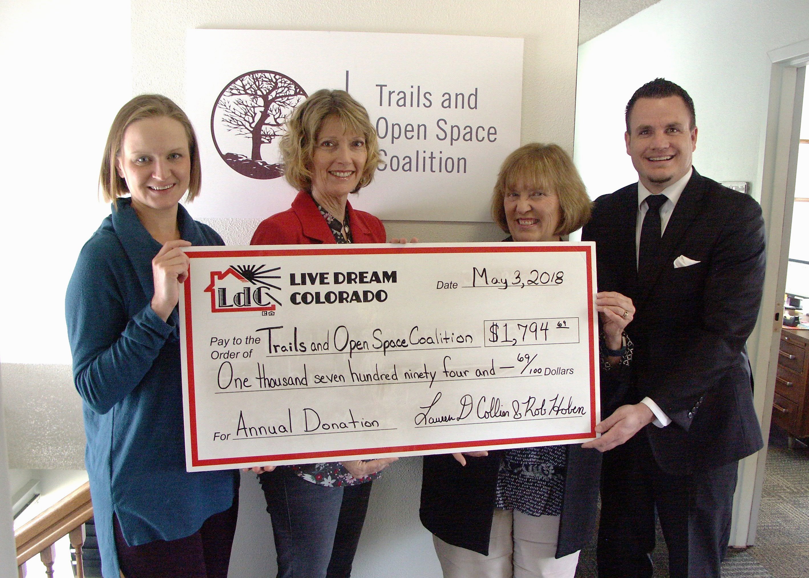 Lauren D Collier and Rob Hoben present donation to Trails and Open Space Coalition Executive Director Susan Davies and Outreach Director Eileen Healy