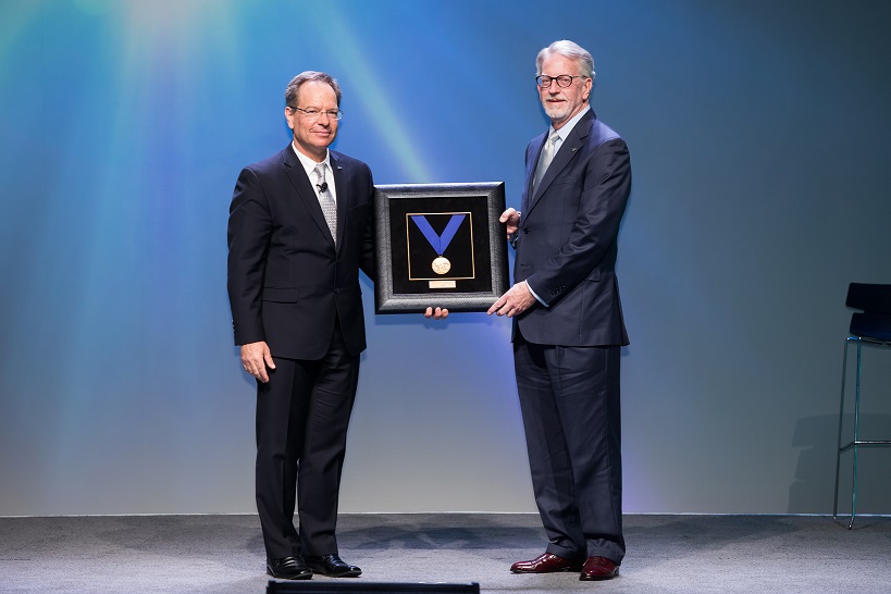 Gregory Saunders (right) accepts the award from SAE President Mircea Gradu, PhD