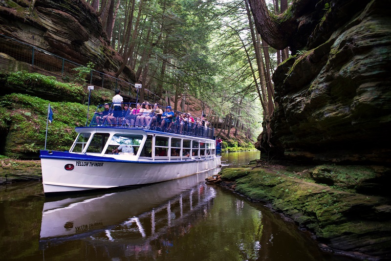 Dells Boat Tours navigate narrow canyons that cut into the wooded shoreline.