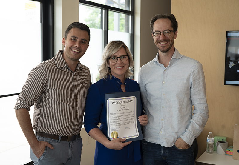 Councilmen Freddie O'Connell and Colby Sledge present Kelly Koeppel, President of k2forma with a proclamation.
