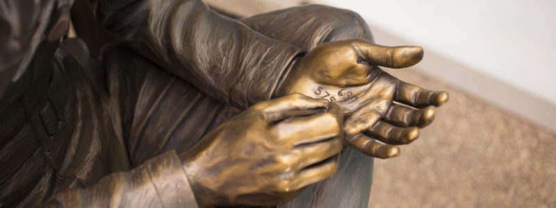 Detail of “Eager Beaver” writing in his hand,  one of twelve figures comprising “Lest We Forget: The Mission” Photo credit: Jafe Parsons