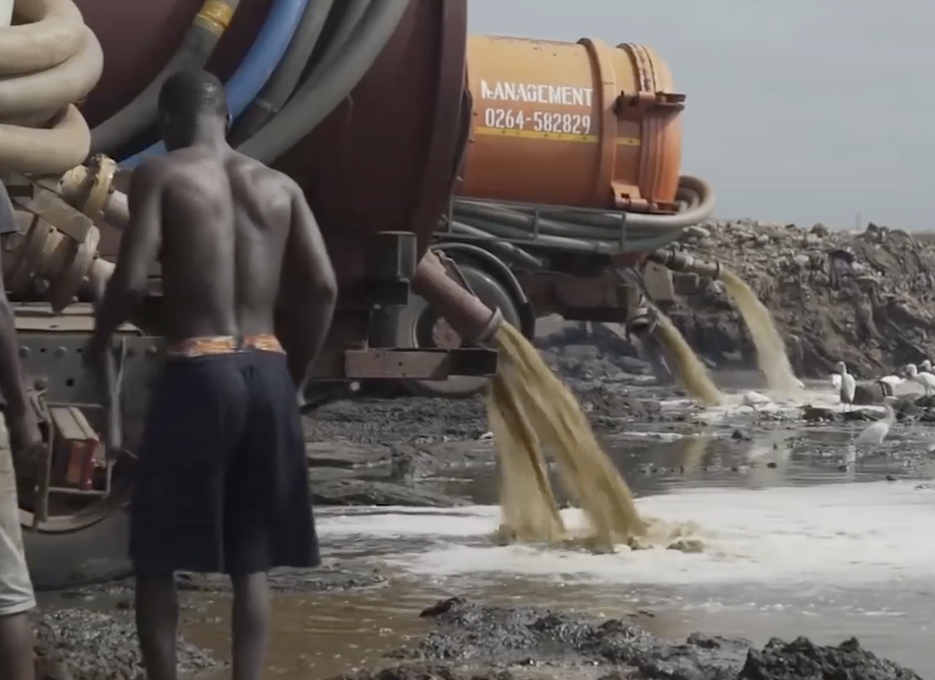 Vacuum trucks offload human waste at a site in Ghana, West Africa. Existing facilities cannot adequately process all the human waste that is collected, and some is offloaded at locations where environ