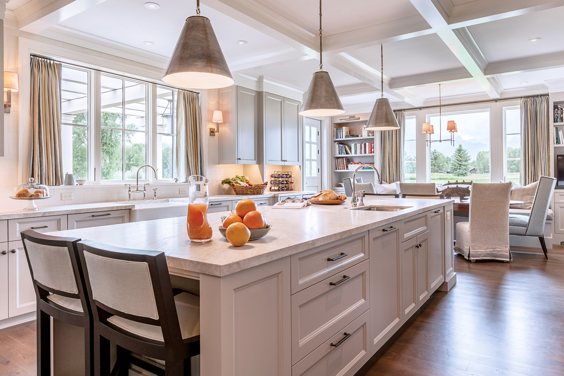An East Coast ranch style home in Jackson Hole created by WRJ Design features a light-filled functional kitchen that blends traditional and contemporary elements while embracing the views.