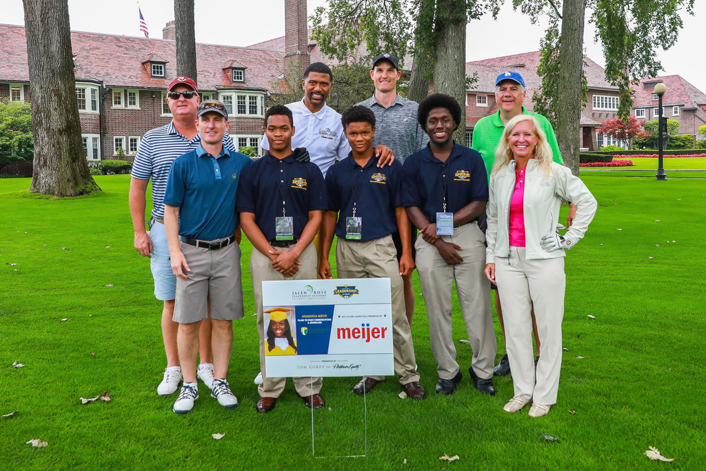 JRLA Student, Jalen Rose and Golf Participants pose with a JRLA Student Leader sign at The 2017 Jalen Rose Golf Classic presented by Tom Gores and Platinum Equity