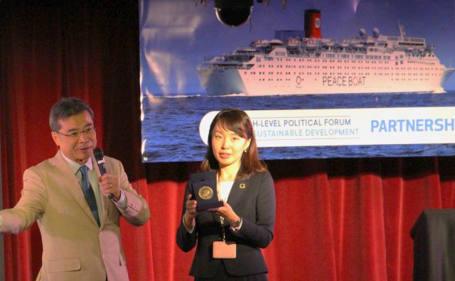 Peace Boat Founder and Director Yoshioka Tatsuya (left) during a Partnership Expo presentation that showcased the Nobel Peace Prize the organization had been awarded the previous year.
