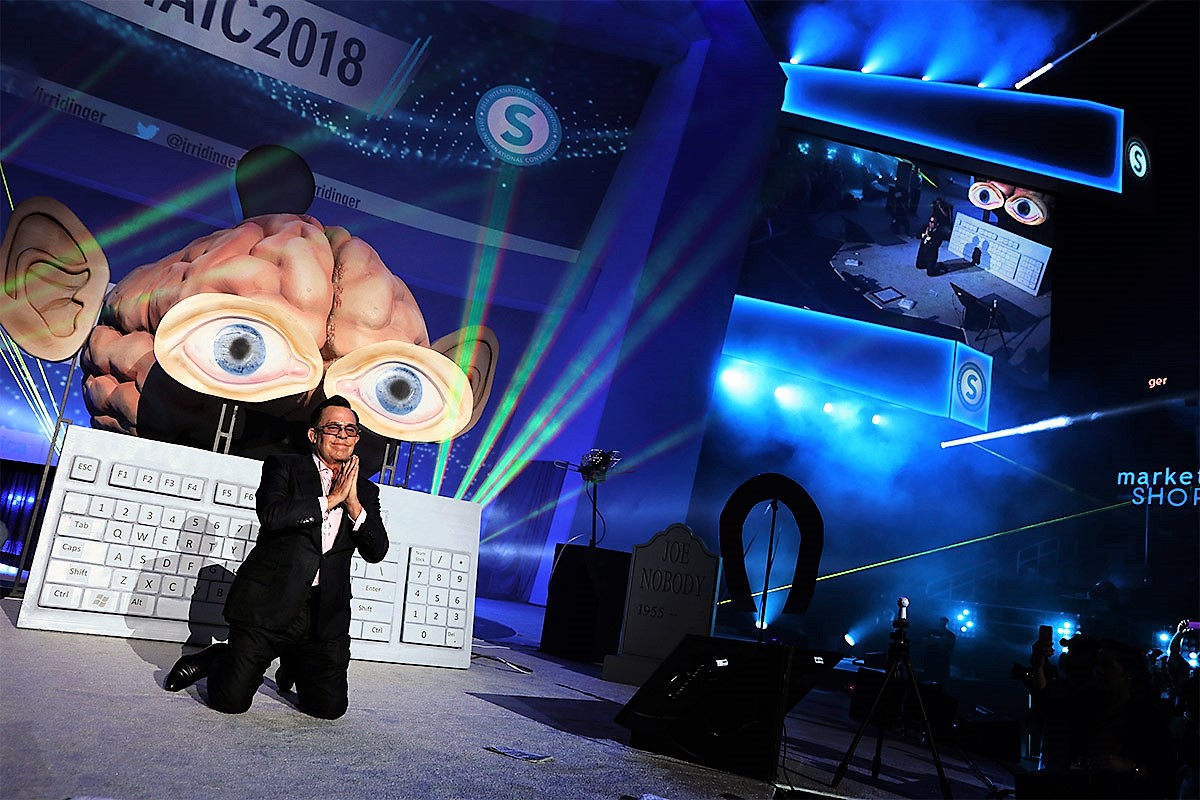 JR Ridinger onstage during his presentation discussing the programming and reprogramming of your brain so that you can succeed.