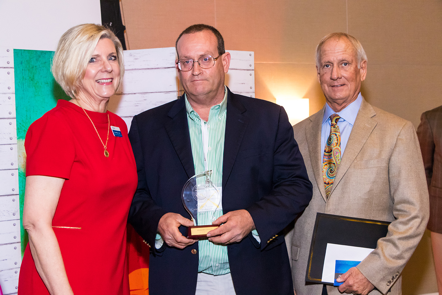 Joe Canaan (C) receives the 2018 Maintenance Caregiver of the Year award from Gara Wilsie, Remedi Senior Care who sponsored the awards, and Jim McWhirter, OKALA Board Chair.