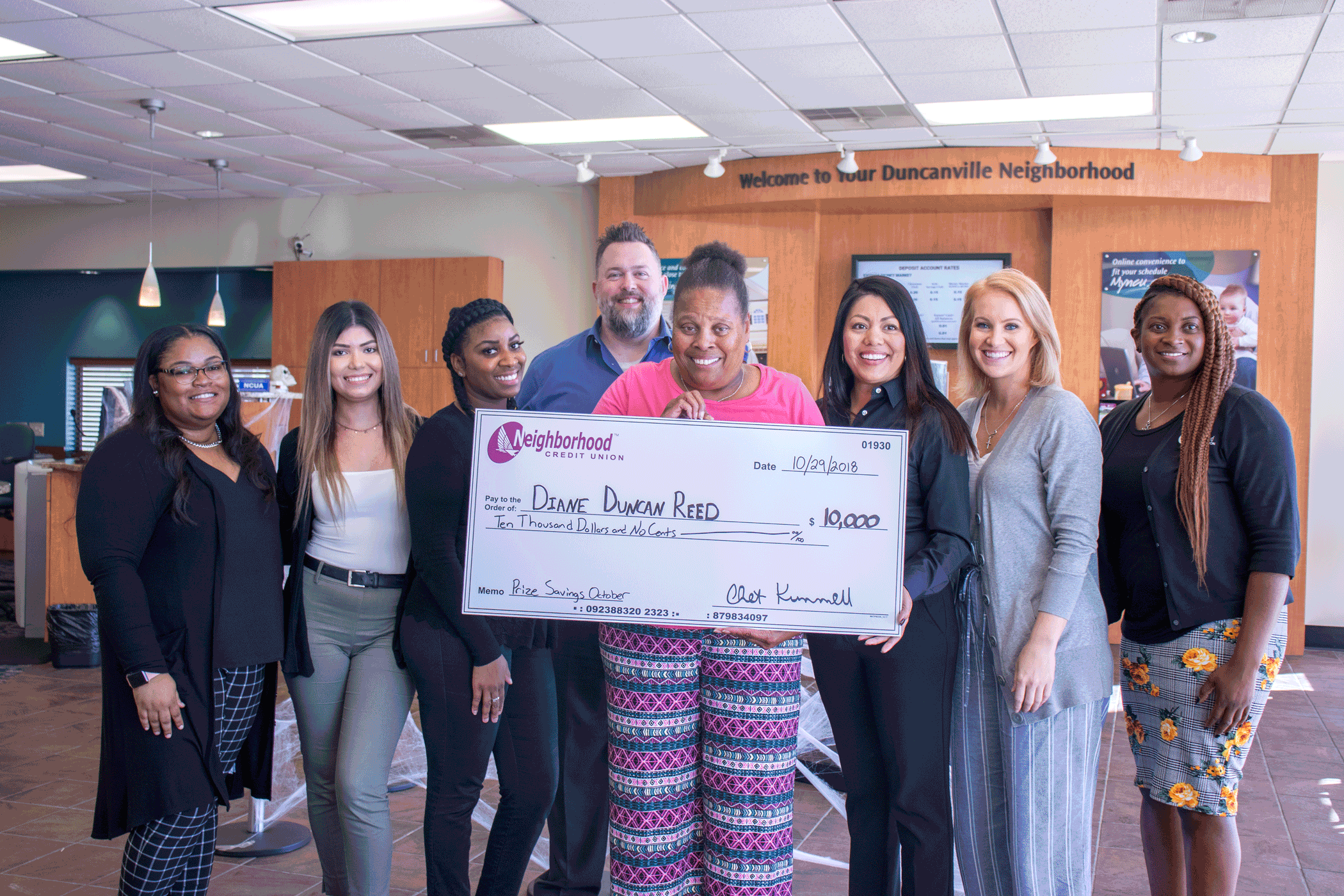 Diane Reed (center) of Duncanville stands with her $10,000 prize from Neighborhood Credit Union alongside the Duncanville branch staff.